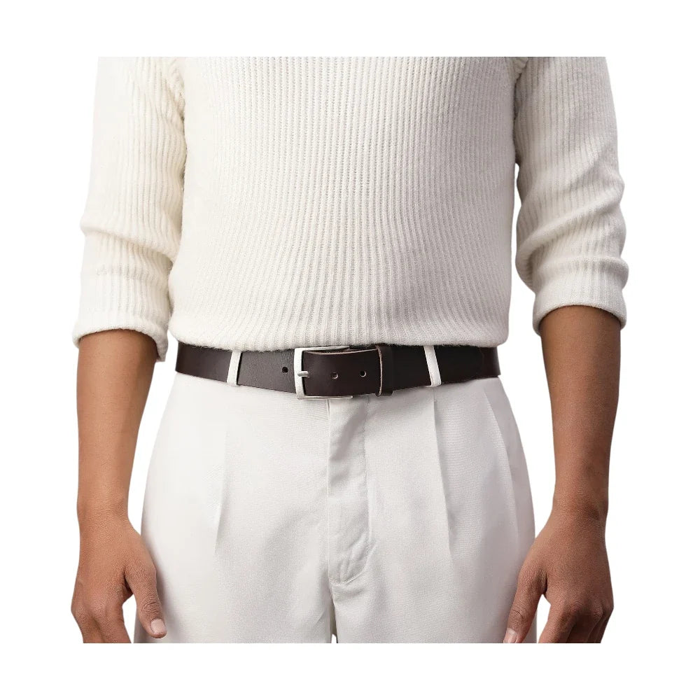 Person wearing a white sweater, white pants, and a brown belt on a white background