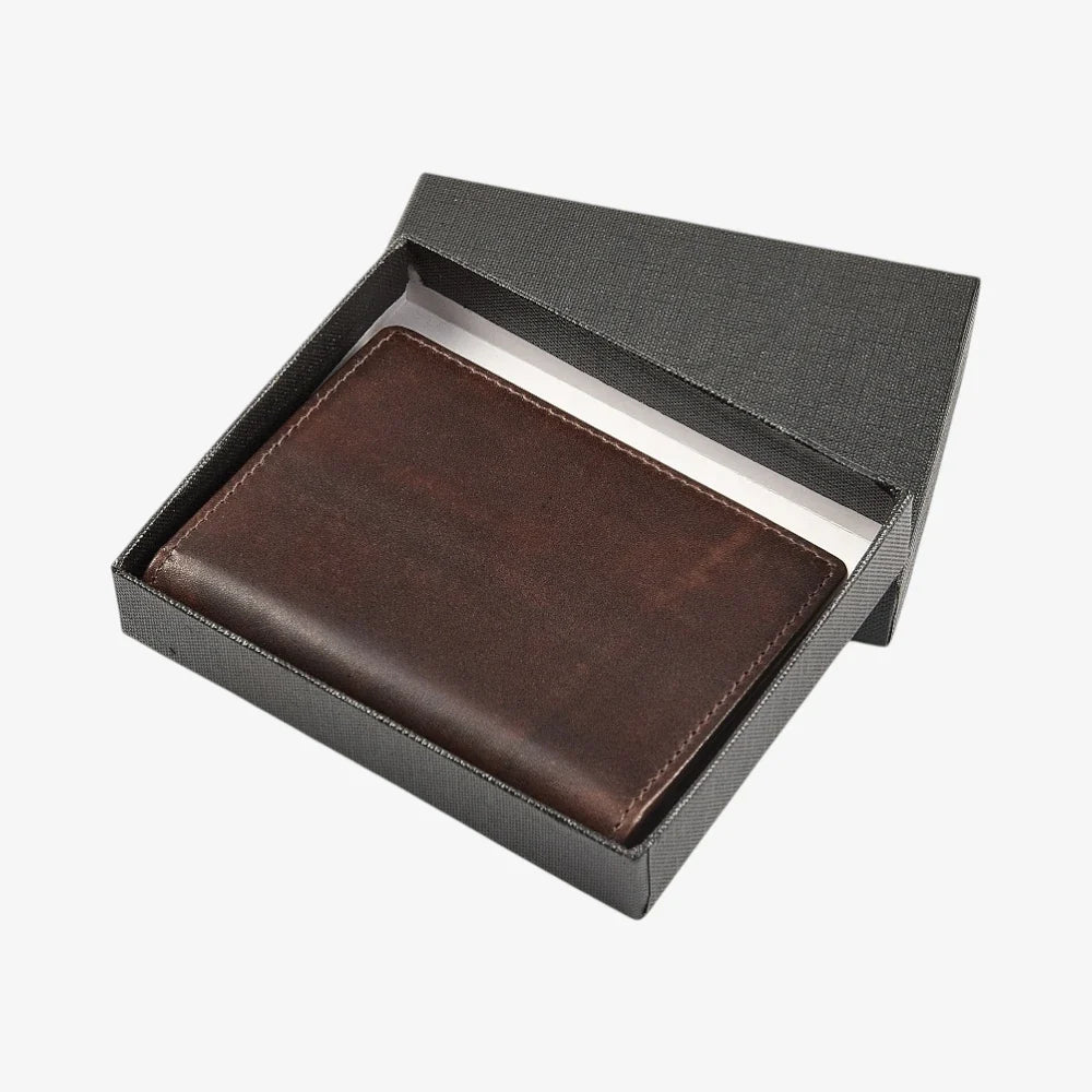 Brown leather credit card holder in a black box on a white background