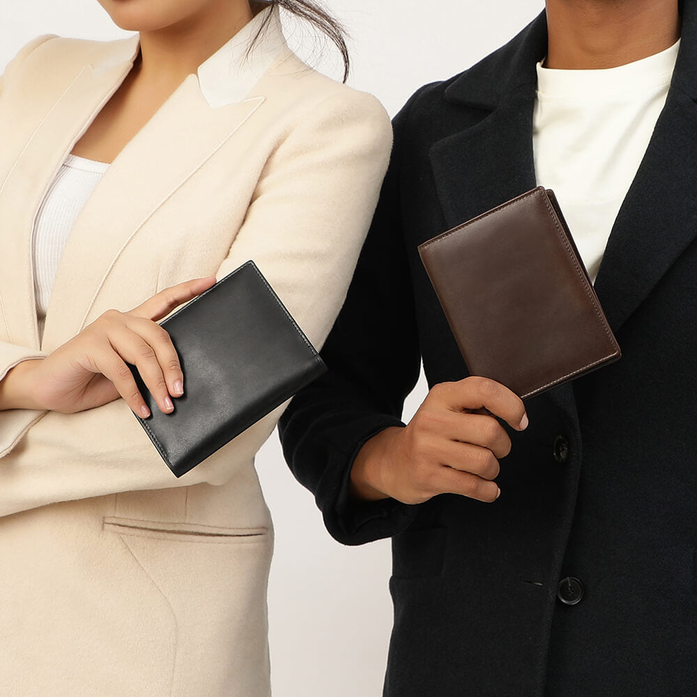 Two people holding leather passport wallets