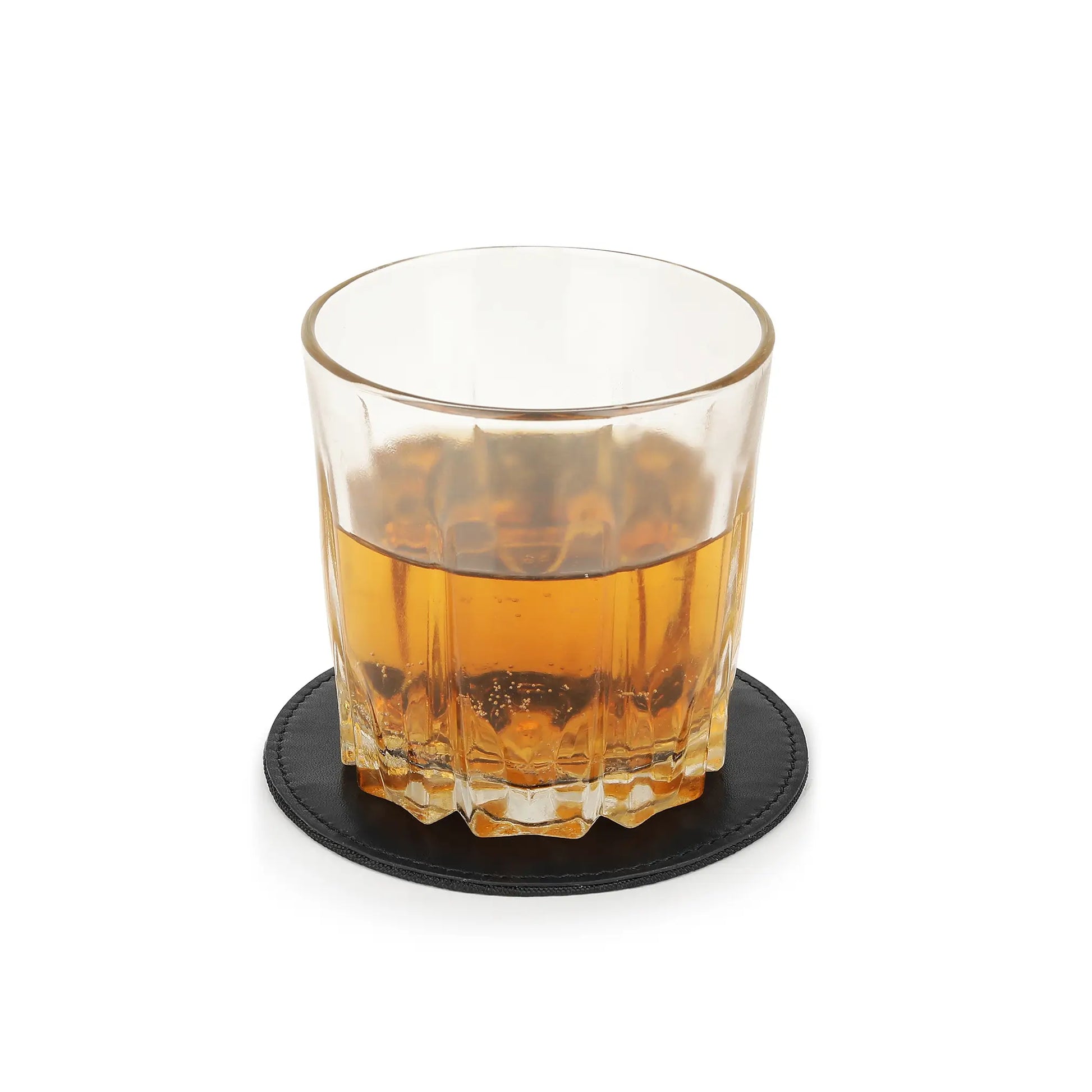 Glass of amber liquid on a black leather coaster with a white background