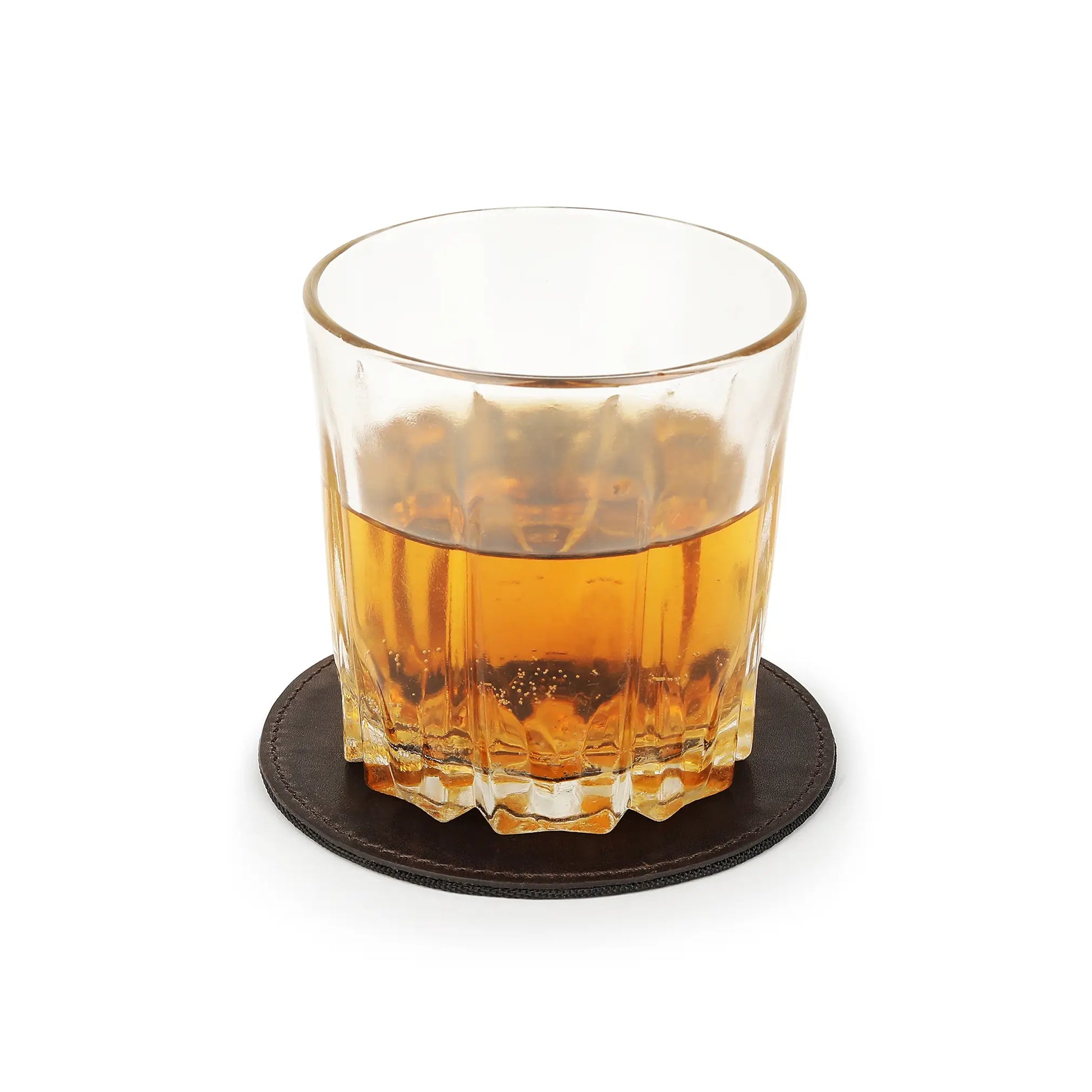 Glass of amber liquid on a brown coaster with a white background