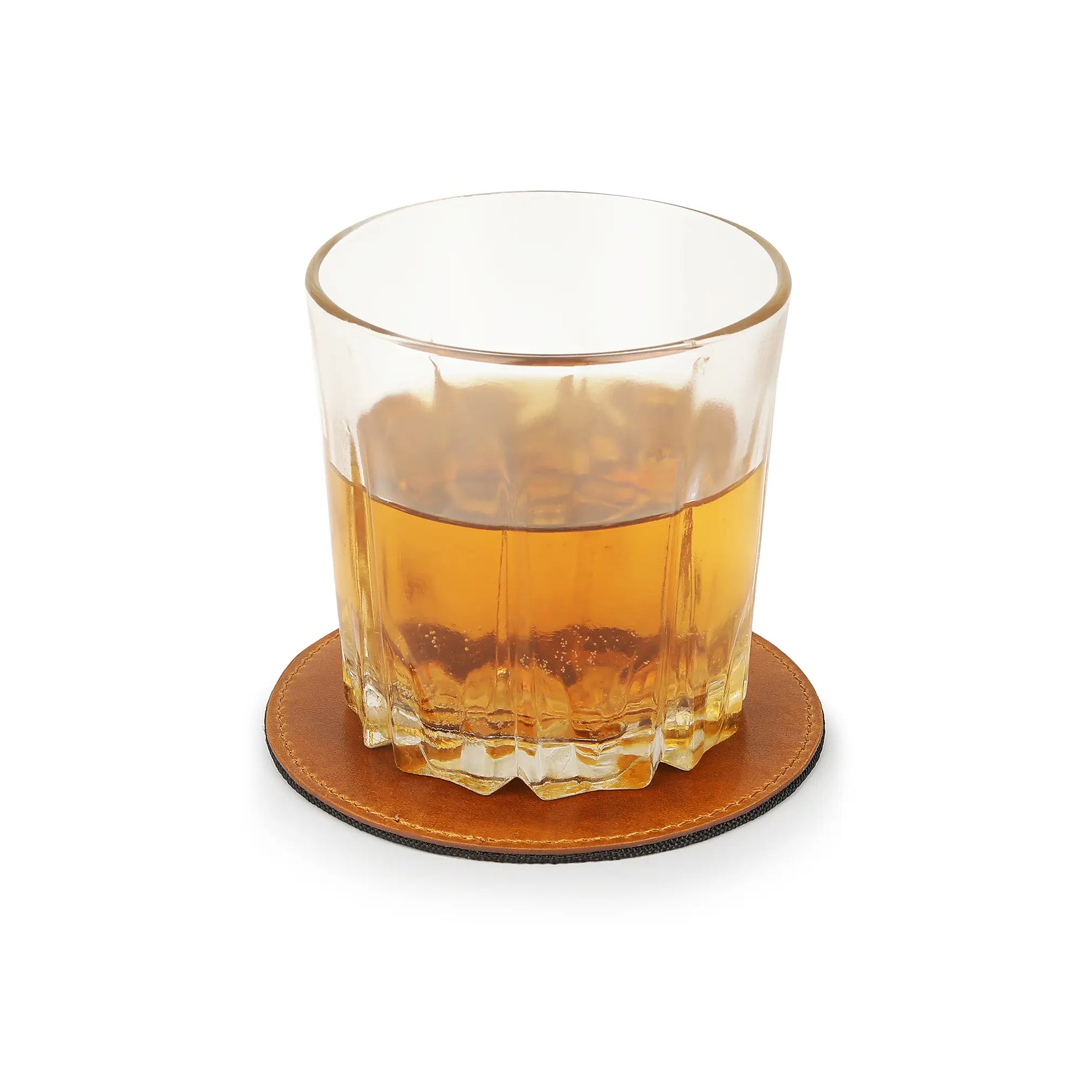 Glass of amber liquid on a tan leather coaster with a white background
