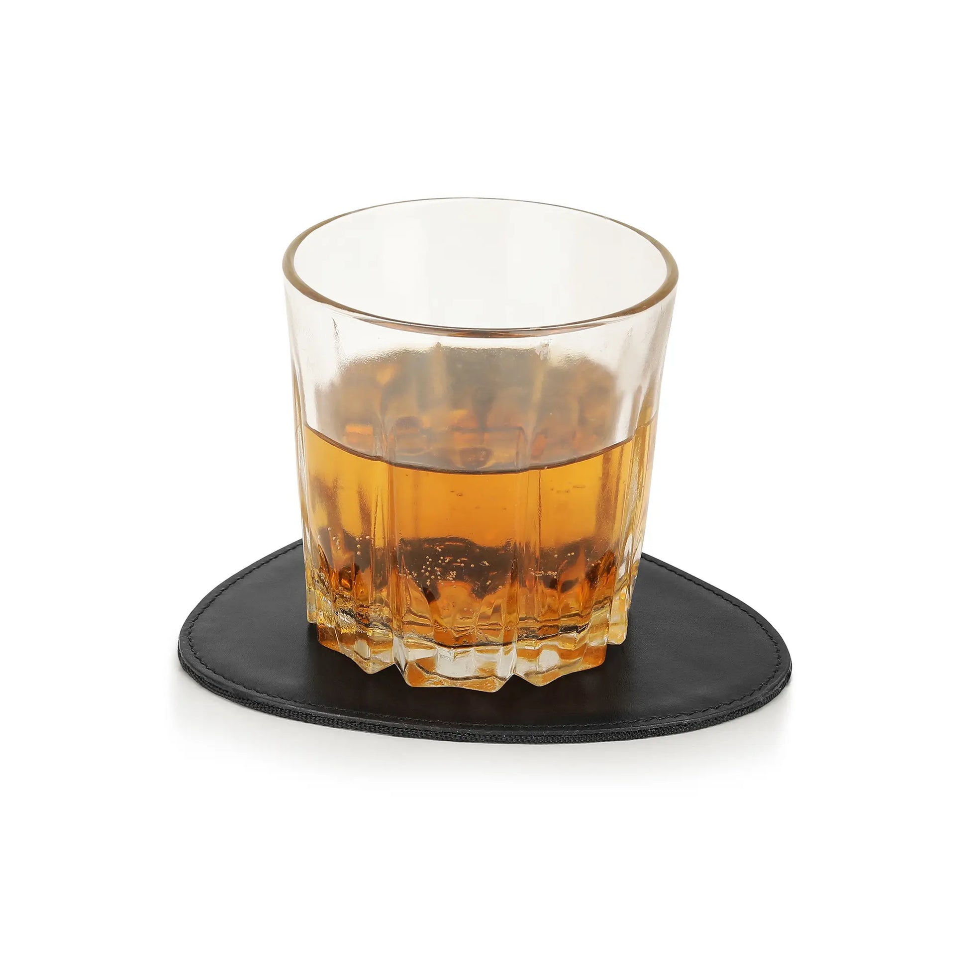 Glass of amber liquid on a black coaster with a white background
