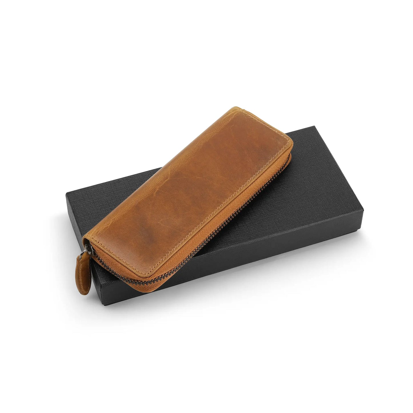 Tan leather pen case on a black box with a white background