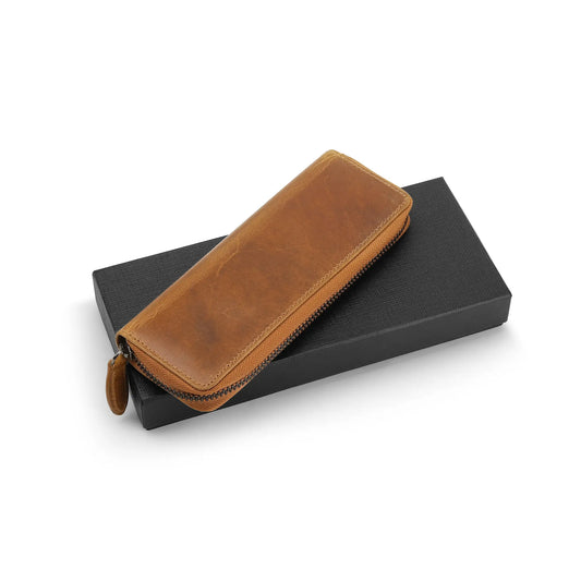 Tan leather pen case on a black box with a white background